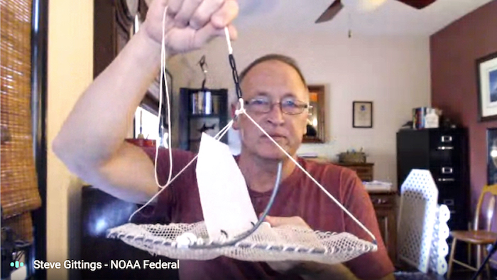 photo of steve gillings holding up model of a lionfish trap