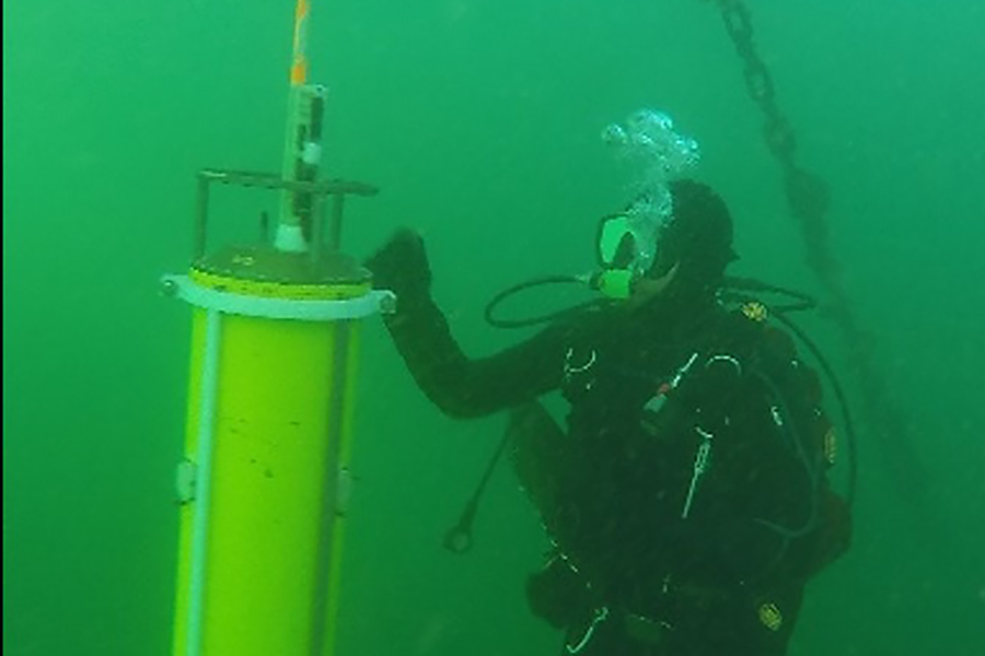 A deep-sea diver with a tethered cylinder
