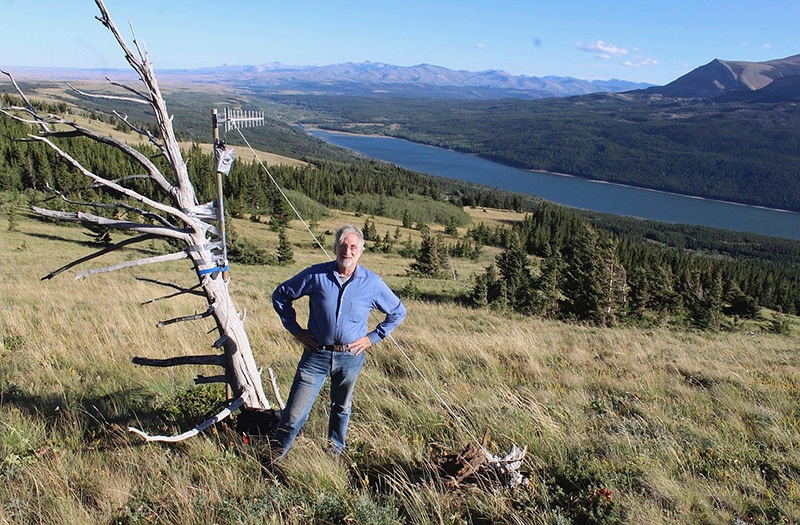 Doug Bonham stands on hillside with camera test device