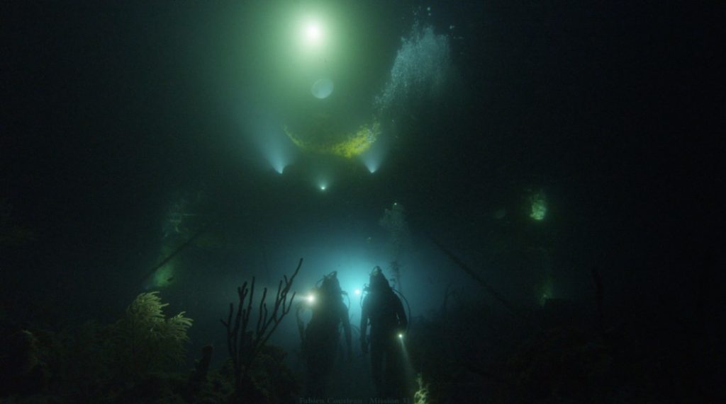 Two divers near the Aquarius lab on an ocean floor