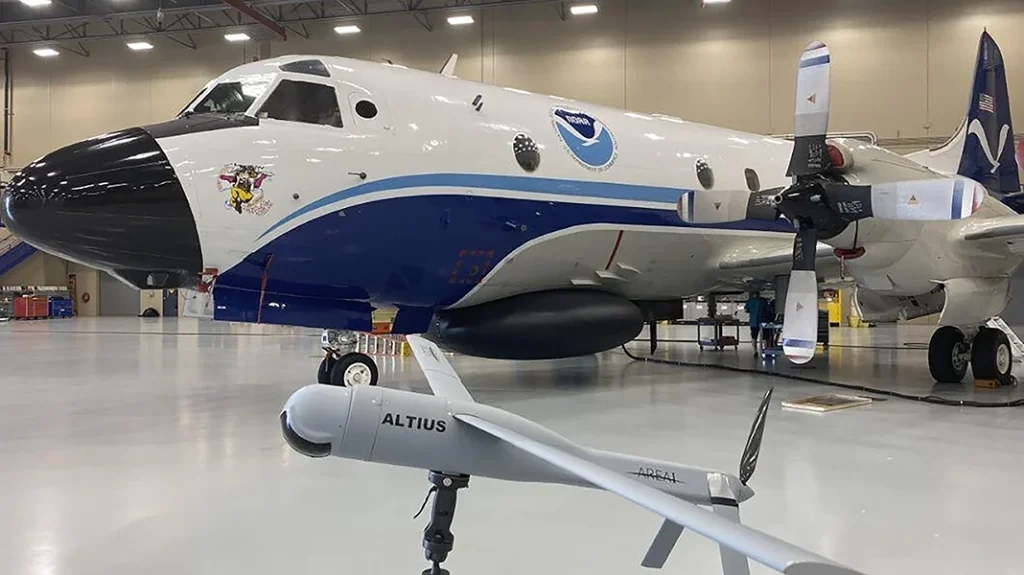 A NOAA Hurricane Hunter aircraft sitting next to an Altius drone